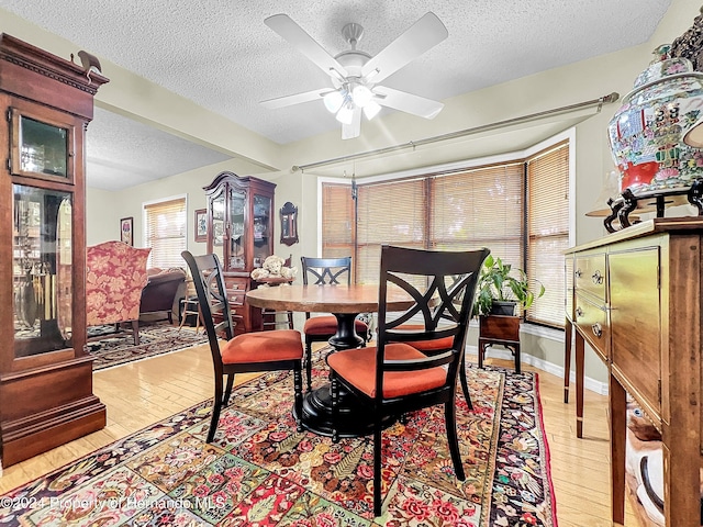 dining space featuring ceiling fan, light hardwood / wood-style flooring, and a textured ceiling