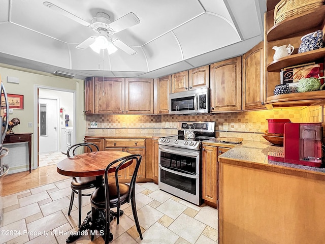 kitchen featuring decorative backsplash, ceiling fan, light wood-type flooring, and appliances with stainless steel finishes