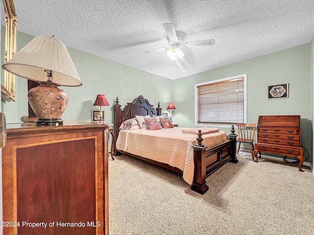 bedroom with a textured ceiling, ceiling fan, and light carpet