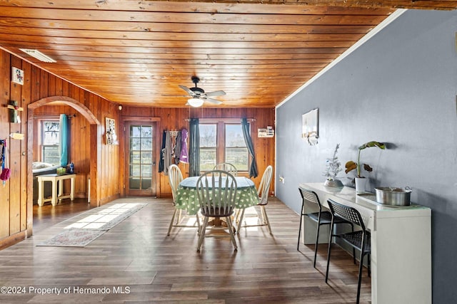 unfurnished dining area with wood walls, hardwood / wood-style floors, and wooden ceiling