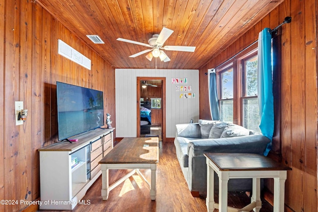 living room with wood walls, hardwood / wood-style floors, ceiling fan, and wooden ceiling