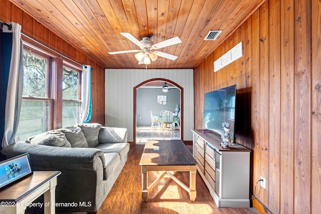 living room featuring wooden walls, ceiling fan, wooden ceiling, and light wood-type flooring