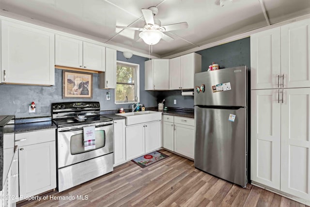 kitchen featuring white cabinetry, ceiling fan, sink, stainless steel appliances, and light hardwood / wood-style flooring