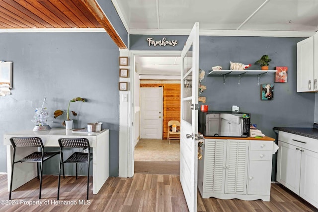 kitchen with hardwood / wood-style flooring and white cabinets