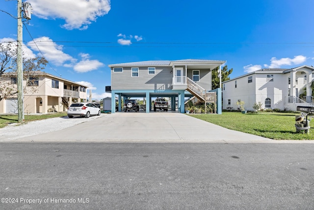 view of front of property with a carport, a porch, and a front yard