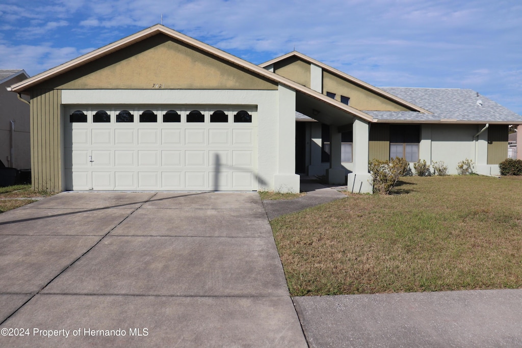 ranch-style home featuring a garage and a front yard