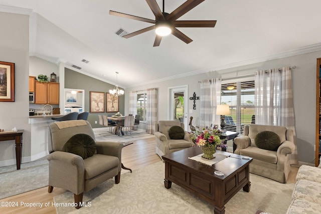 living room with a healthy amount of sunlight, light wood-type flooring, ornamental molding, and lofted ceiling