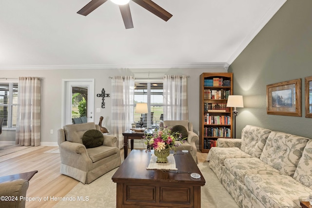 living room with light hardwood / wood-style floors, crown molding, and a wealth of natural light