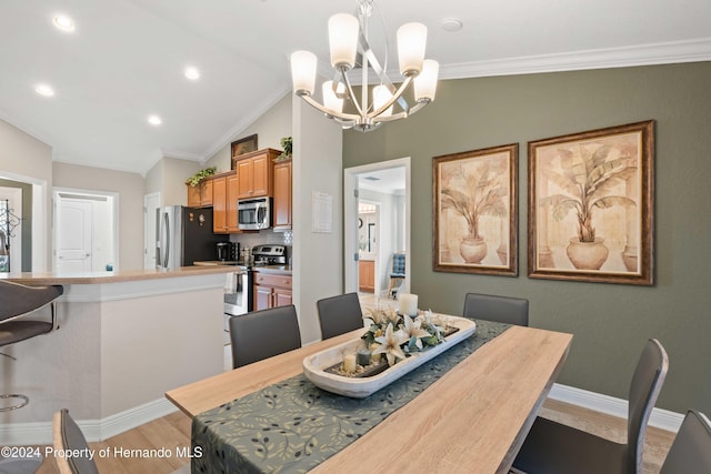 dining area with an inviting chandelier, light hardwood / wood-style floors, lofted ceiling, and ornamental molding