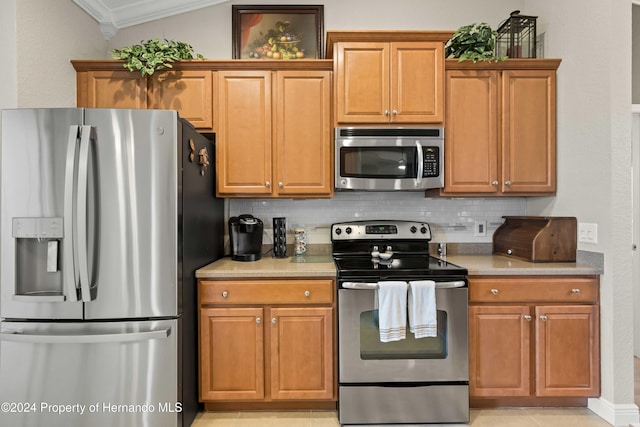 kitchen with tasteful backsplash, crown molding, light tile patterned floors, and appliances with stainless steel finishes