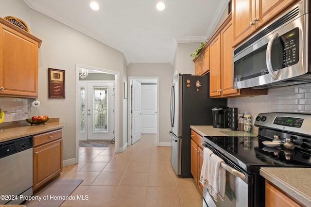 kitchen featuring decorative backsplash, ornamental molding, stainless steel appliances, light tile patterned floors, and lofted ceiling