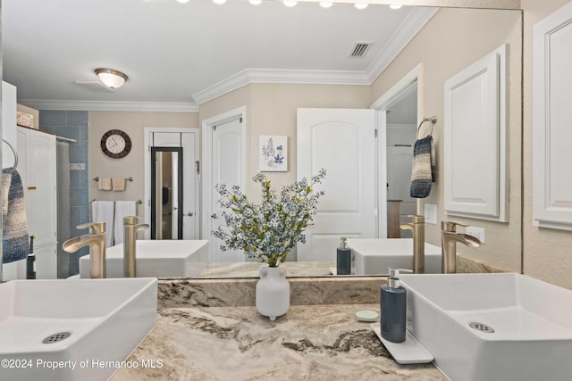 bathroom with a shower, crown molding, and sink