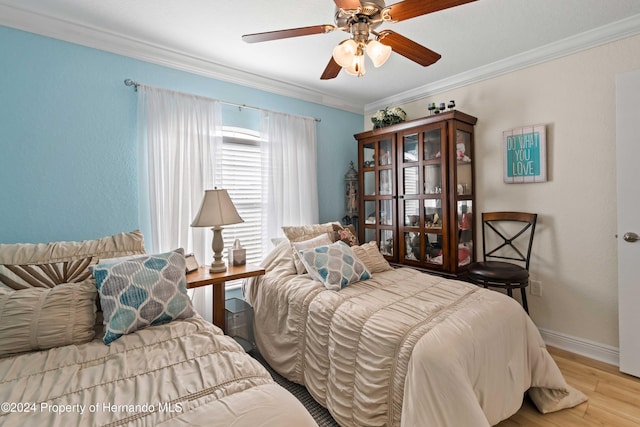 bedroom with crown molding, ceiling fan, and light hardwood / wood-style floors