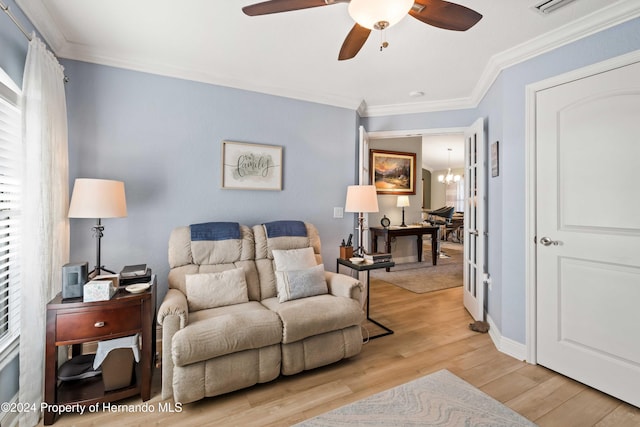 living room featuring ceiling fan with notable chandelier, light hardwood / wood-style floors, and ornamental molding