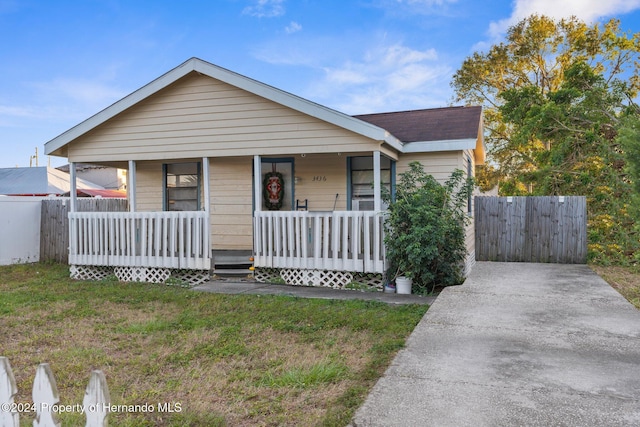 view of front of home with covered porch and a front yard