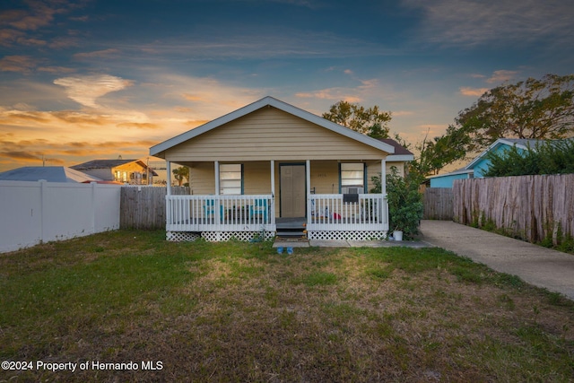 bungalow-style house featuring a lawn and covered porch