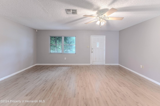 spare room with ceiling fan, light hardwood / wood-style flooring, and a textured ceiling