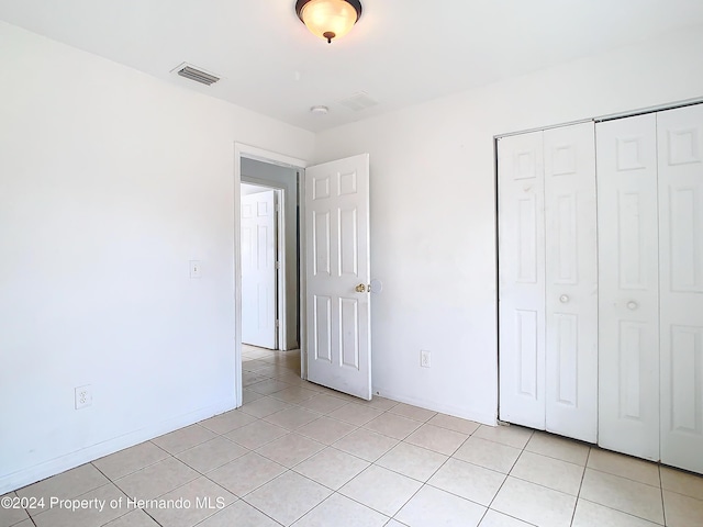 unfurnished bedroom with a closet and light tile patterned floors