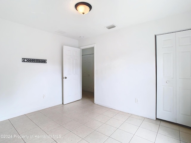 unfurnished bedroom featuring a closet and light tile patterned flooring