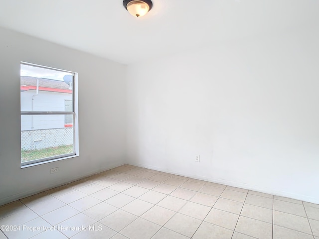 unfurnished room featuring light tile patterned floors and a wealth of natural light