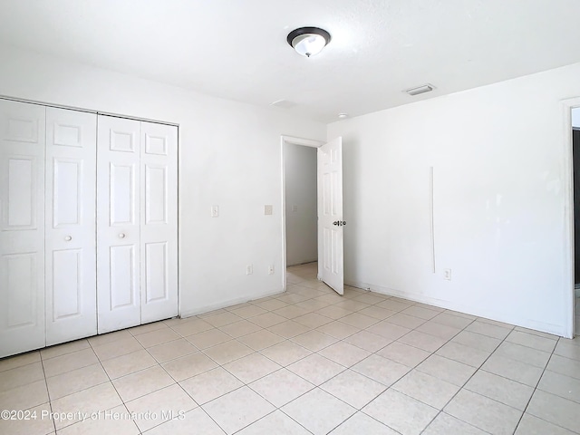 unfurnished bedroom with light tile patterned floors and a closet