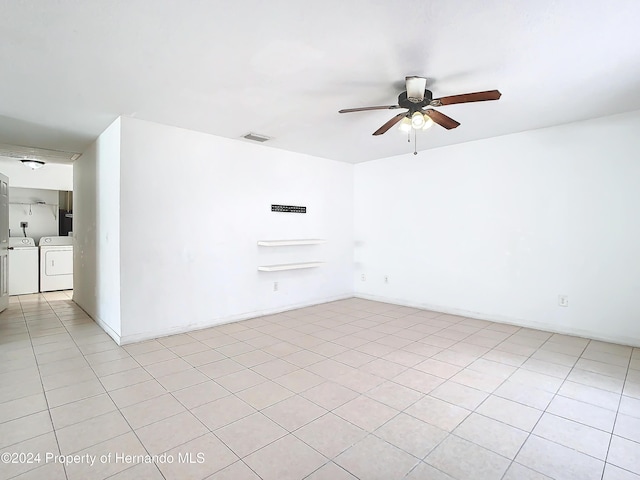 unfurnished room with washing machine and clothes dryer, ceiling fan, and light tile patterned flooring