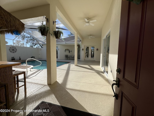 view of pool featuring a lanai, a patio area, french doors, and an outdoor bar