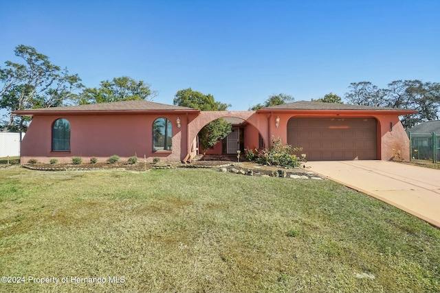 ranch-style house featuring a garage and a front yard