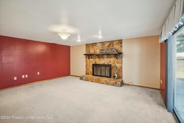 unfurnished living room featuring light carpet and a fireplace