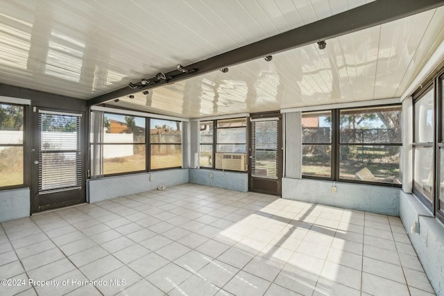 unfurnished sunroom featuring beam ceiling