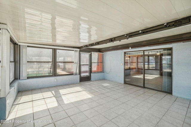 unfurnished sunroom featuring track lighting