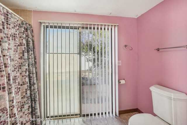 bathroom with a shower with curtain and toilet