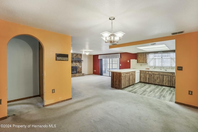 kitchen with carpet, pendant lighting, a chandelier, and kitchen peninsula