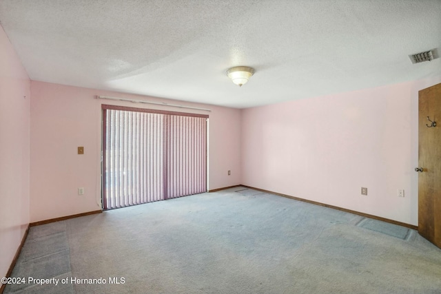 carpeted spare room featuring a textured ceiling