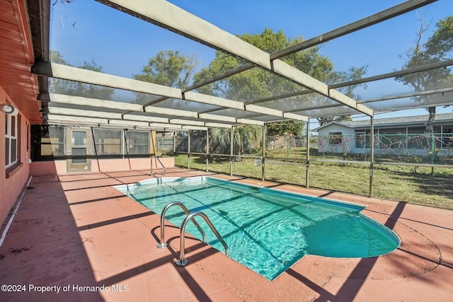 view of swimming pool with a patio, a yard, and glass enclosure