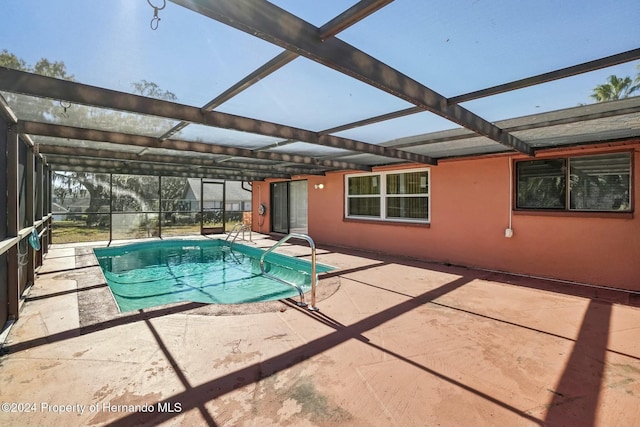 view of pool featuring glass enclosure and a patio area