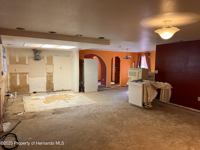 kitchen with range, fridge, decorative light fixtures, and a textured ceiling