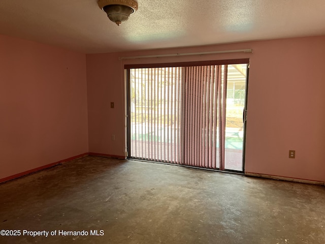 empty room with concrete flooring and a textured ceiling