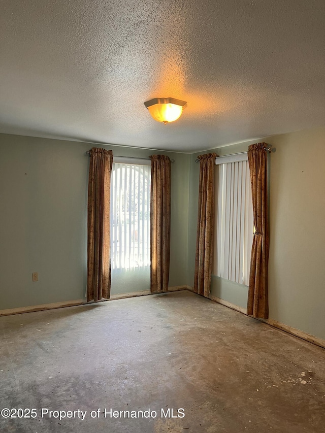 unfurnished room featuring concrete flooring and a textured ceiling