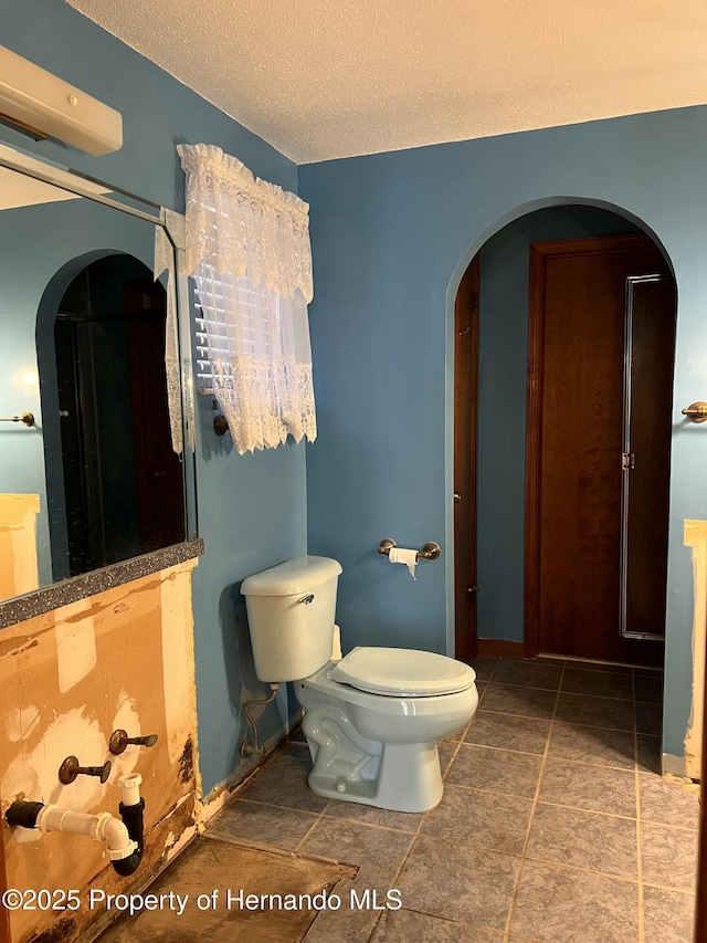 bathroom with toilet and a textured ceiling