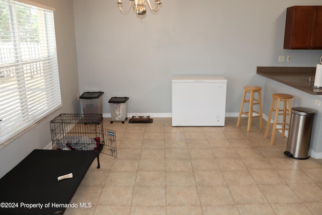 dining space with light tile patterned floors and a notable chandelier