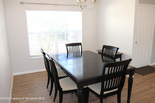 dining room with hardwood / wood-style flooring and an inviting chandelier