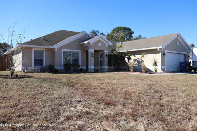 single story home with a garage and a front lawn