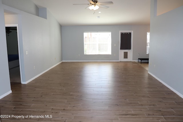 empty room with ceiling fan and dark hardwood / wood-style flooring