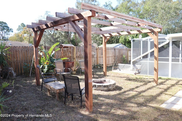 view of yard with a pergola, an outdoor fire pit, and a sunroom