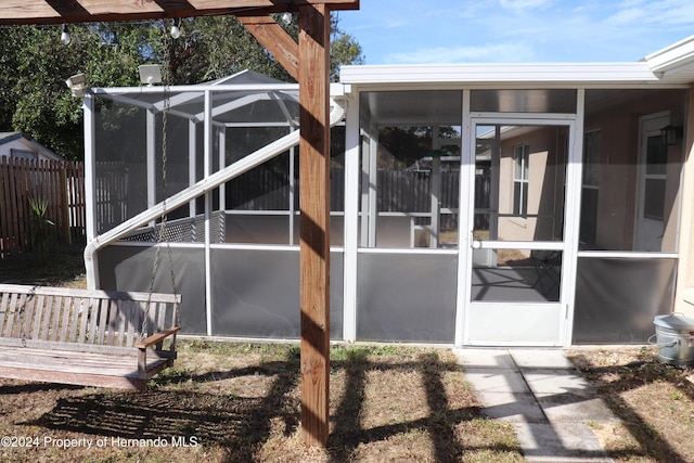 back of house featuring glass enclosure and a sunroom