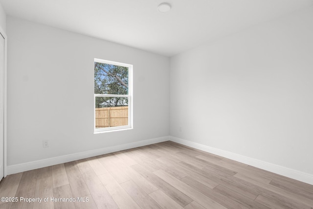 spare room with light wood-type flooring and baseboards