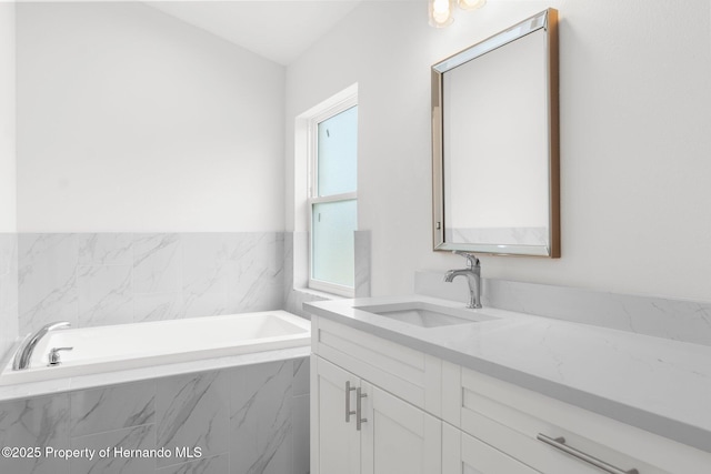 bathroom featuring a garden tub and vanity