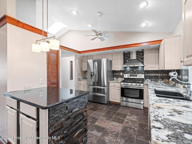 kitchen with tasteful backsplash, wall chimney exhaust hood, stainless steel appliances, sink, and lofted ceiling