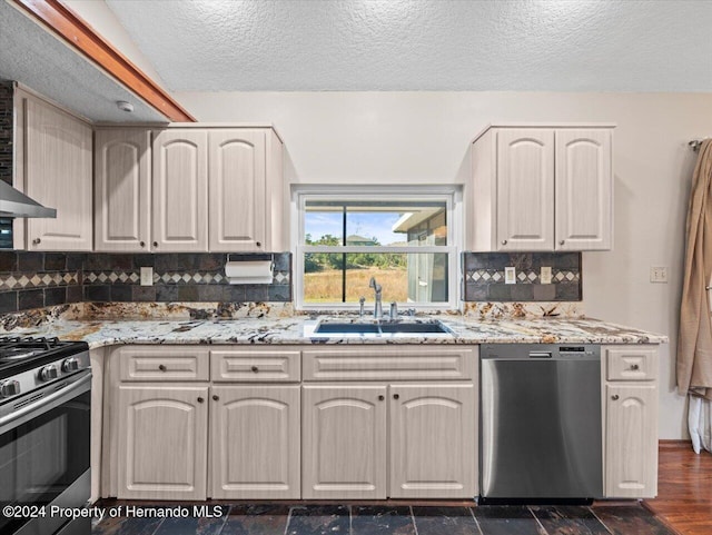 kitchen with decorative backsplash, light stone countertops, stainless steel appliances, dark wood-type flooring, and sink